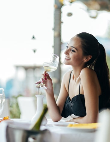 woman smiling while holding wine glass