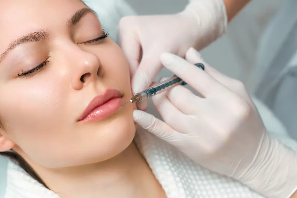 Injecting syringe to woman's lip