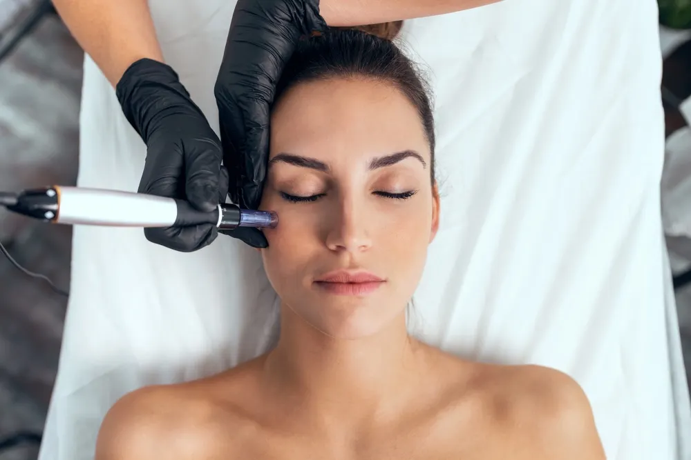 Woman laying down while being administered facial medical treatment