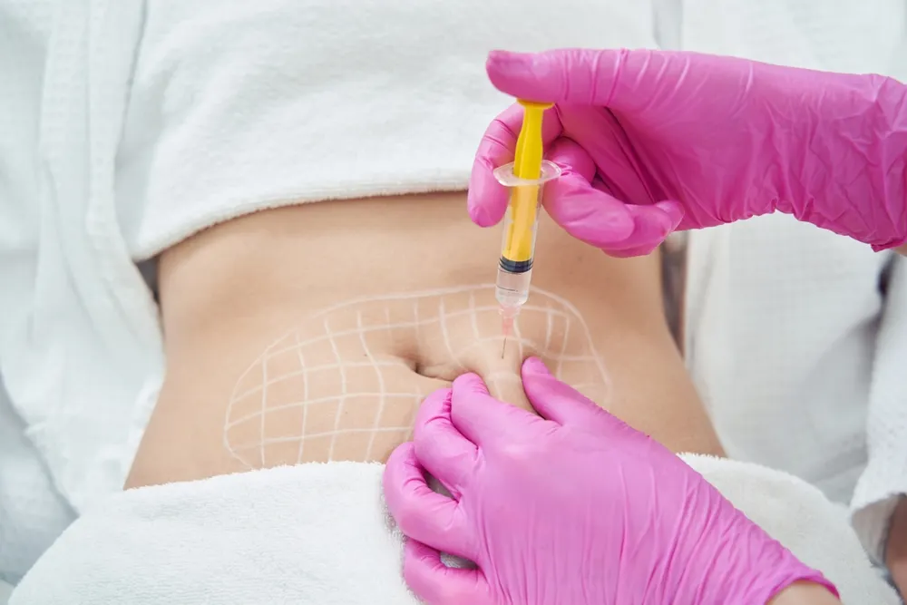 Person being injected in abdominal area with syringe