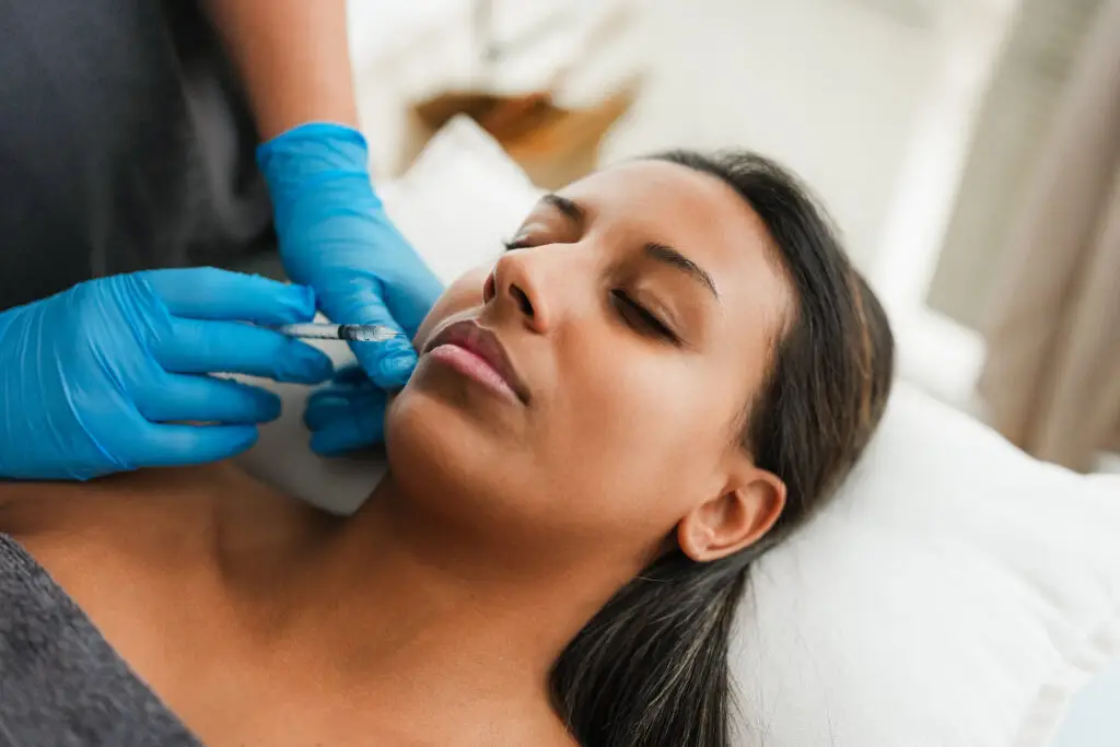 Young woman doing botox treatment inside private miami beach medical clinic - Beauty trends and anti aging concept - Focus on face