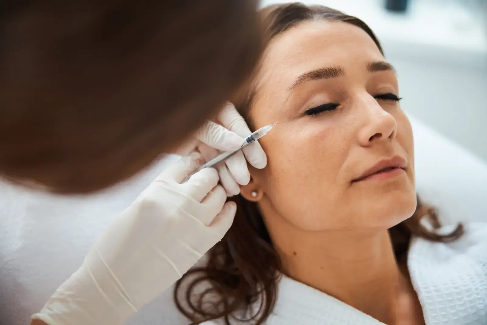 Crow's feet treatment in Miami Beach — nurse practitioner softening the lines at the outer corner of a patient's eye
